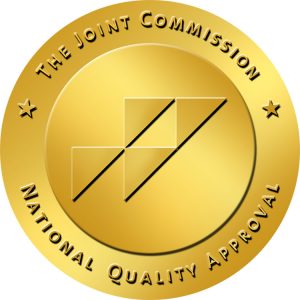Gold circular badge with black diagonal lines and geometric shapes in the center, surrounded by the text 